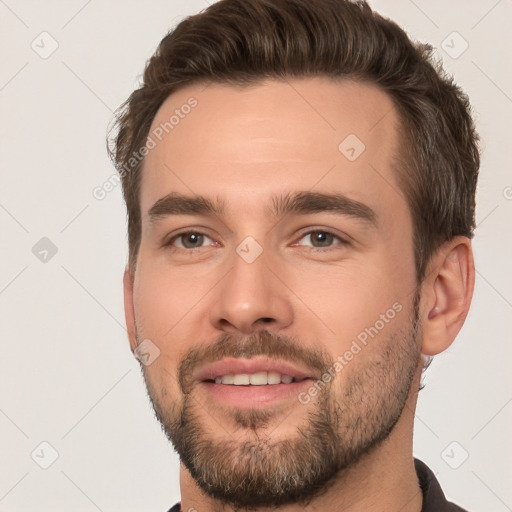 Joyful white young-adult male with short  brown hair and brown eyes