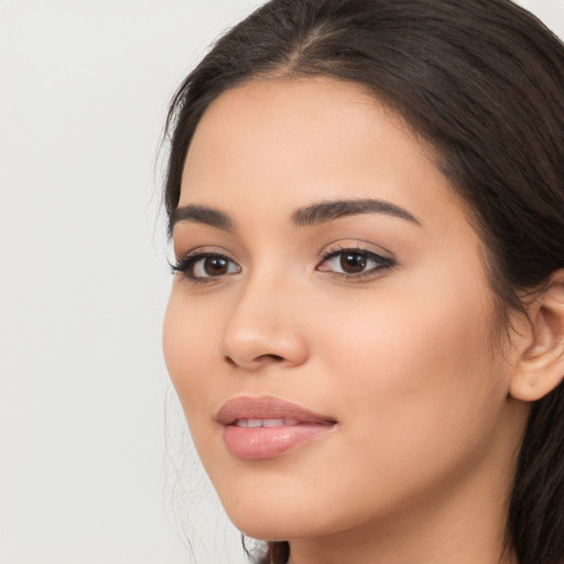 Joyful latino young-adult female with long  brown hair and brown eyes