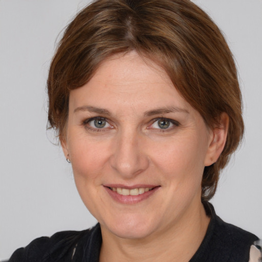 Joyful white adult female with medium  brown hair and grey eyes