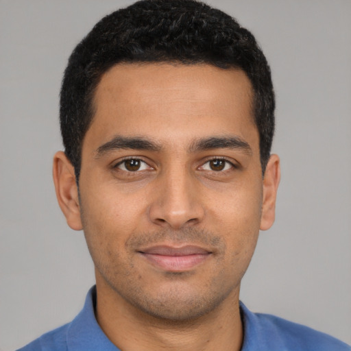 Joyful latino young-adult male with short  black hair and brown eyes