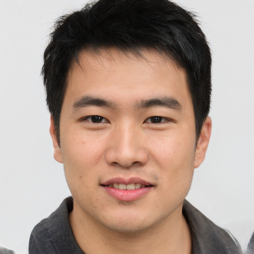 Joyful asian young-adult male with short  brown hair and brown eyes
