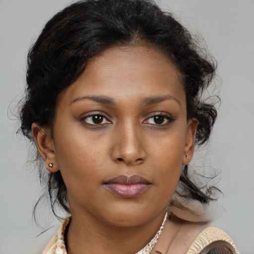 Joyful black young-adult female with medium  brown hair and brown eyes
