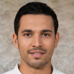 Joyful white young-adult male with short  black hair and brown eyes