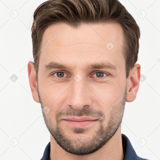 Joyful white young-adult male with short  brown hair and grey eyes