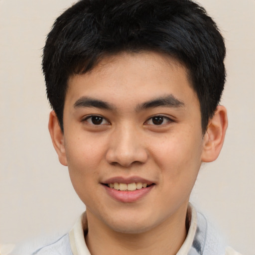 Joyful asian young-adult male with short  black hair and brown eyes