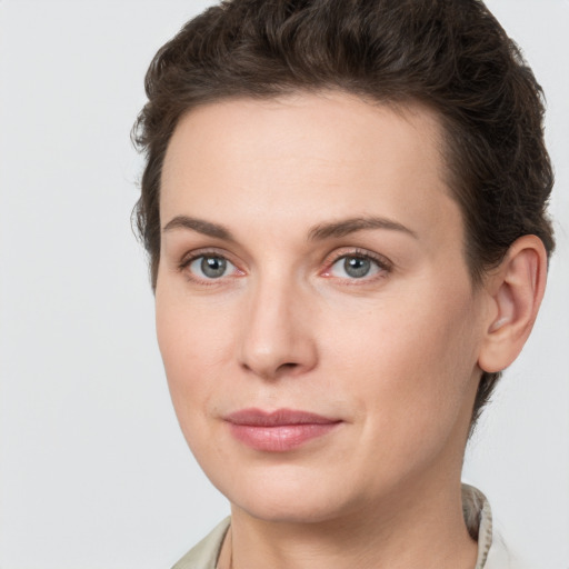 Joyful white young-adult female with short  brown hair and grey eyes