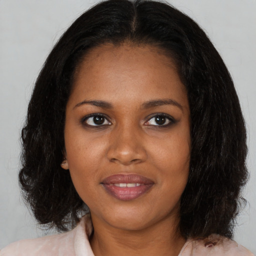 Joyful black young-adult female with medium  brown hair and brown eyes