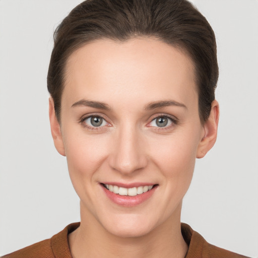 Joyful white young-adult female with short  brown hair and grey eyes