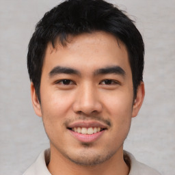 Joyful asian young-adult male with short  black hair and brown eyes