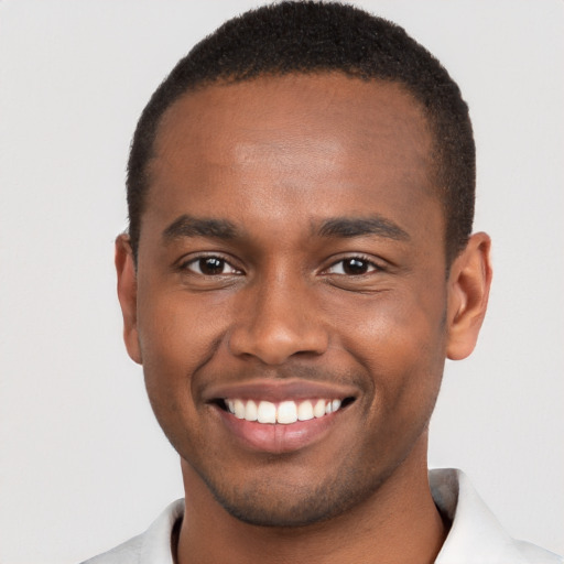 Joyful black young-adult male with short  brown hair and brown eyes