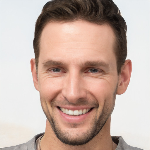 Joyful white young-adult male with short  brown hair and brown eyes