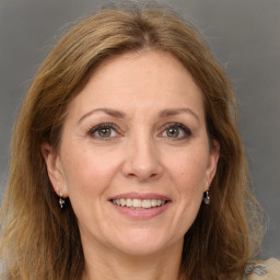 Joyful white adult female with long  brown hair and grey eyes