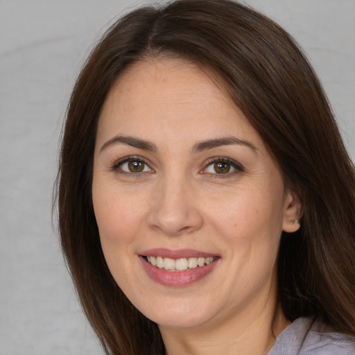 Joyful white young-adult female with long  brown hair and brown eyes