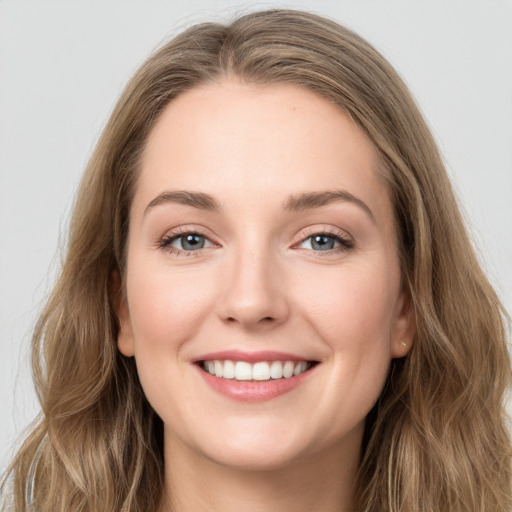 Joyful white young-adult female with long  brown hair and grey eyes