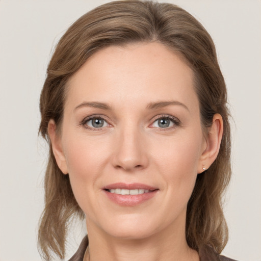 Joyful white young-adult female with medium  brown hair and grey eyes