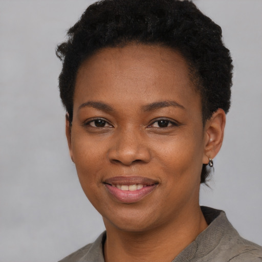 Joyful black young-adult female with short  black hair and brown eyes