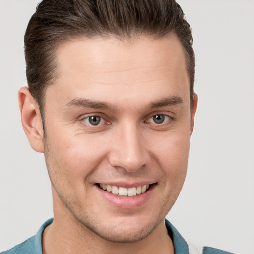 Joyful white young-adult male with short  brown hair and grey eyes