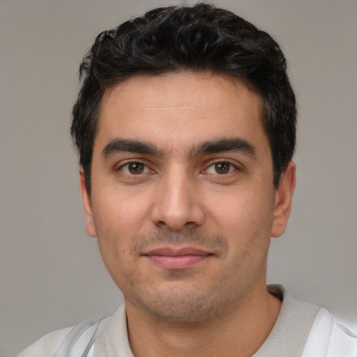 Joyful white young-adult male with short  black hair and brown eyes