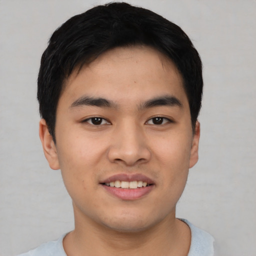 Joyful asian young-adult male with short  black hair and brown eyes