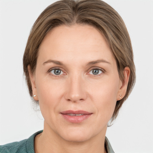 Joyful white adult female with medium  brown hair and grey eyes