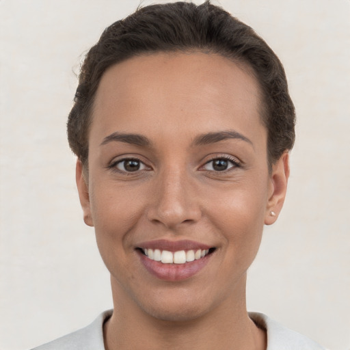 Joyful white young-adult female with short  brown hair and brown eyes