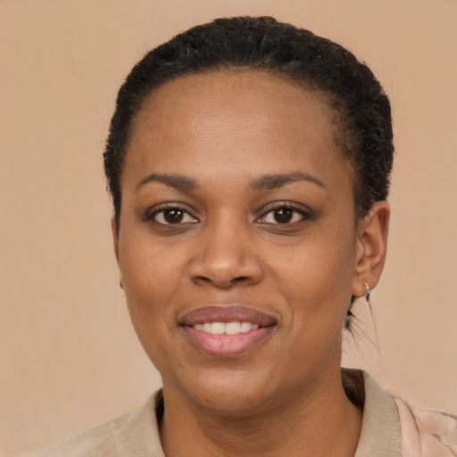 Joyful black young-adult female with short  black hair and brown eyes