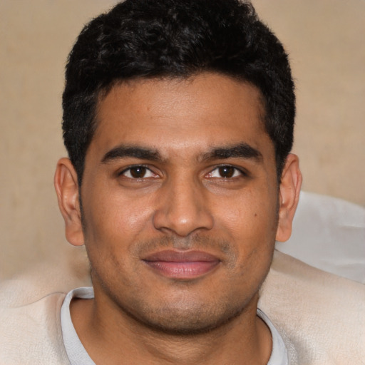 Joyful black young-adult male with short  black hair and brown eyes