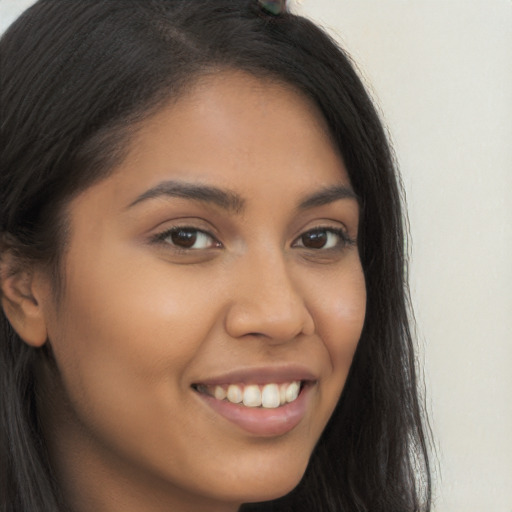 Joyful latino young-adult female with long  brown hair and brown eyes