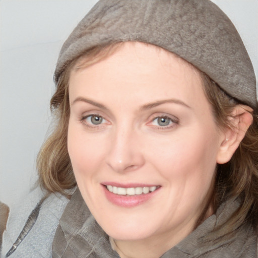 Joyful white young-adult female with medium  brown hair and blue eyes