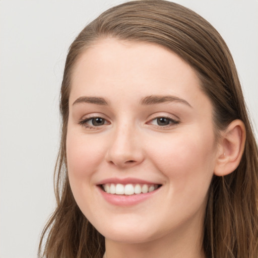 Joyful white young-adult female with long  brown hair and blue eyes