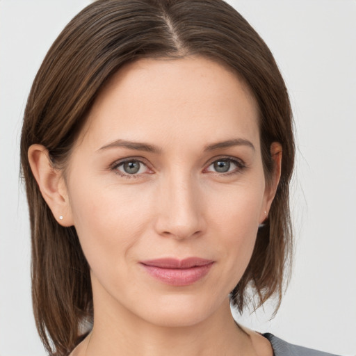 Joyful white young-adult female with medium  brown hair and grey eyes