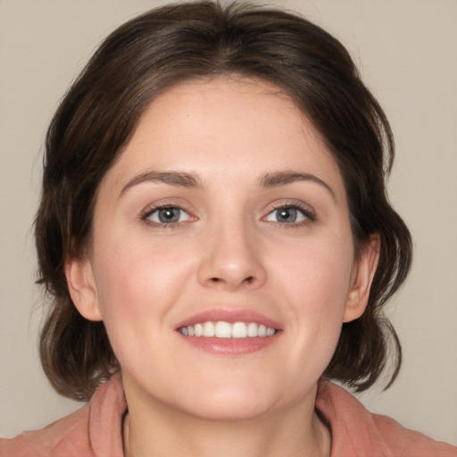 Joyful white young-adult female with medium  brown hair and blue eyes