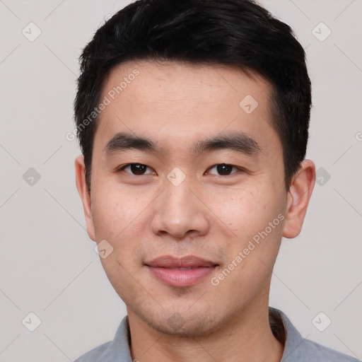 Joyful asian young-adult male with short  black hair and brown eyes