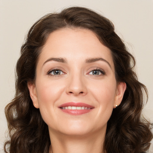 Joyful white young-adult female with medium  brown hair and green eyes