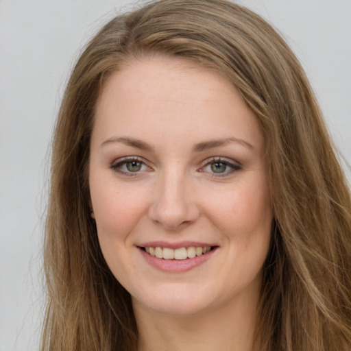 Joyful white young-adult female with long  brown hair and green eyes