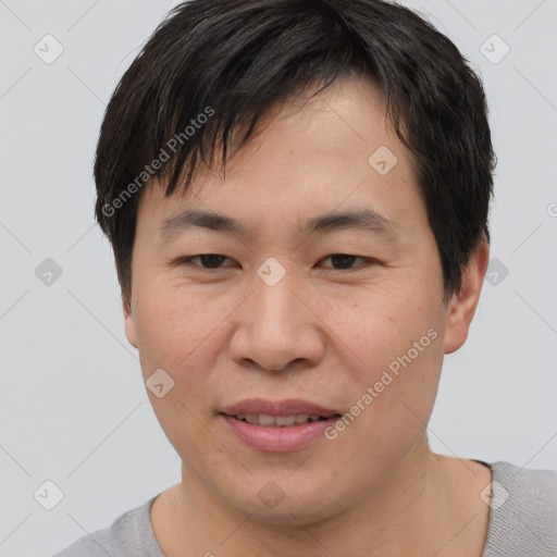 Joyful asian young-adult male with short  brown hair and brown eyes