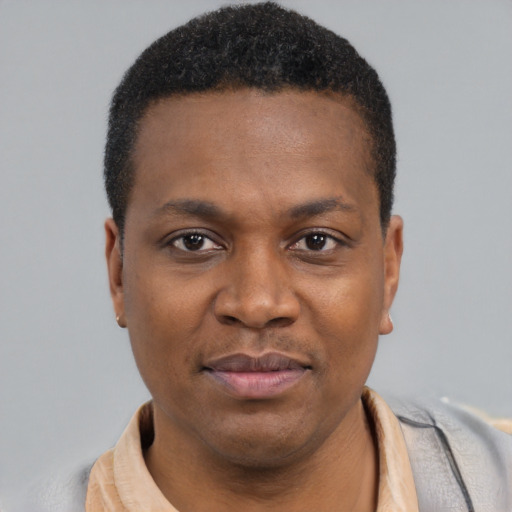 Joyful black young-adult male with short  black hair and brown eyes