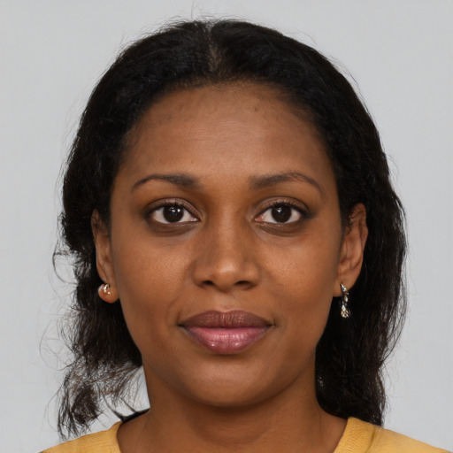 Joyful black young-adult female with medium  brown hair and brown eyes