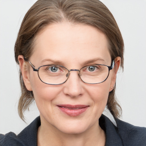 Joyful white adult female with medium  brown hair and blue eyes