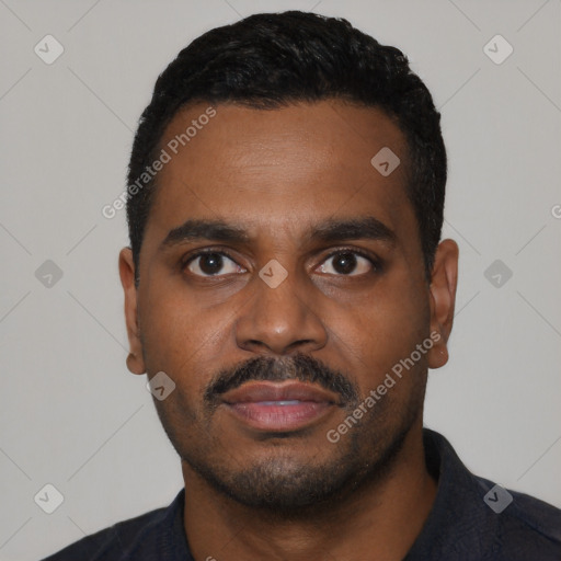 Joyful black young-adult male with short  black hair and brown eyes