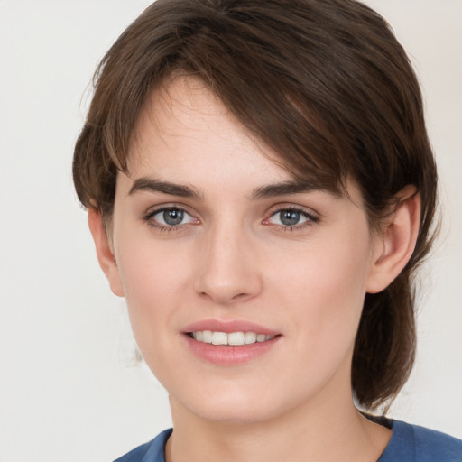 Joyful white young-adult female with medium  brown hair and grey eyes