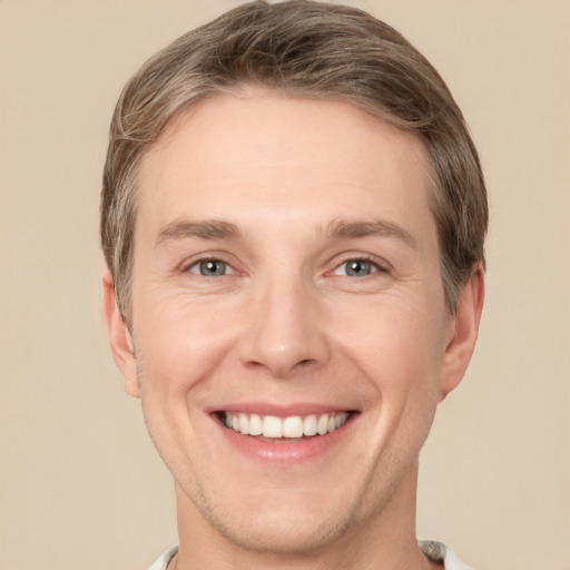 Joyful white adult male with short  brown hair and grey eyes