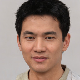 Joyful asian young-adult male with short  black hair and brown eyes