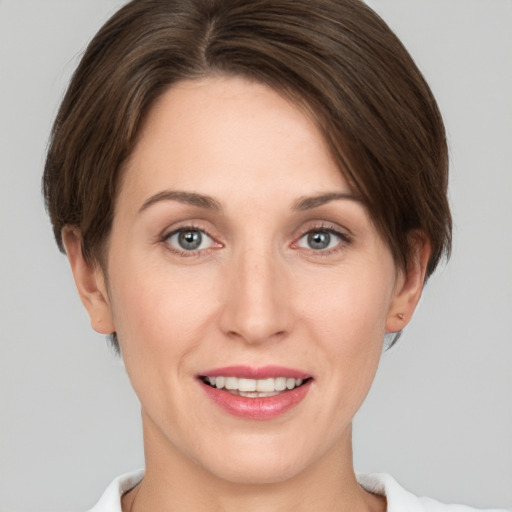 Joyful white young-adult female with short  brown hair and grey eyes