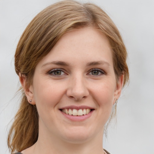 Joyful white young-adult female with medium  brown hair and green eyes