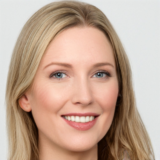 Joyful white young-adult female with long  brown hair and blue eyes