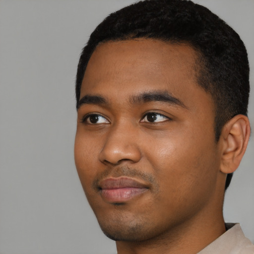 Joyful black young-adult male with short  black hair and brown eyes
