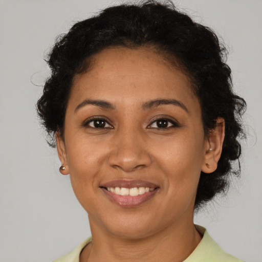 Joyful latino young-adult female with short  brown hair and brown eyes