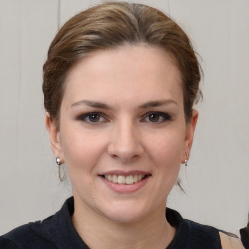 Joyful white young-adult female with medium  brown hair and grey eyes