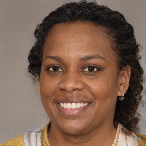 Joyful black adult female with medium  brown hair and brown eyes